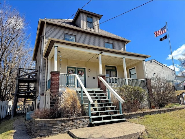 american foursquare style home featuring a porch and stairs