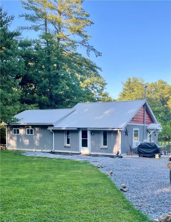 rear view of house with a yard and metal roof