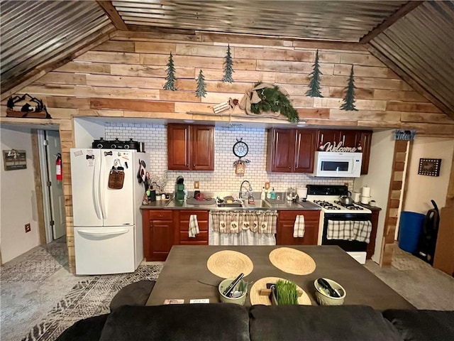 kitchen featuring decorative backsplash, white appliances, lofted ceiling, and a sink