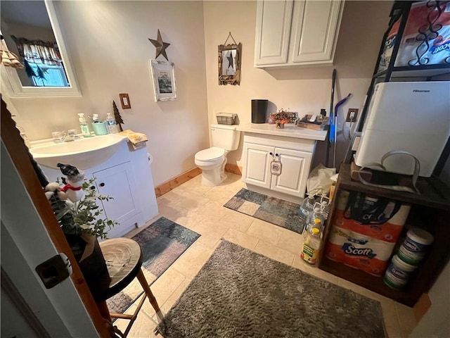 bathroom with vanity, toilet, and baseboards