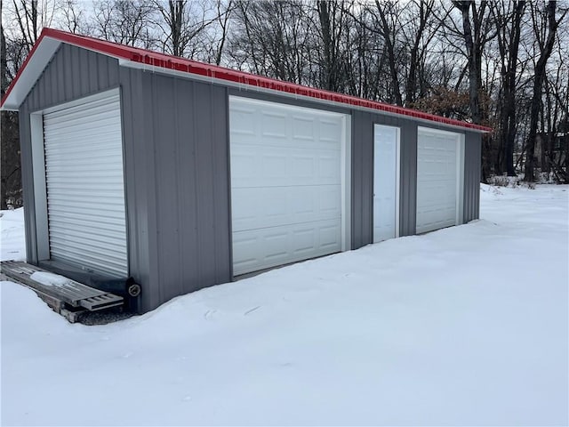 snow covered garage featuring a garage