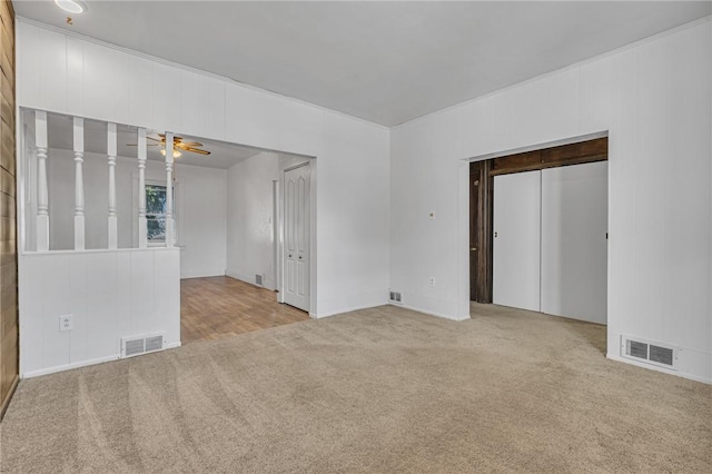 empty room with a ceiling fan, visible vents, and carpet floors