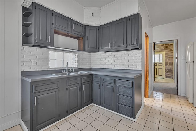 kitchen with a sink, gray cabinetry, freestanding refrigerator, light tile patterned flooring, and open shelves