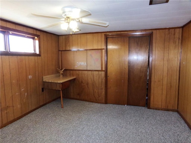 unfurnished bedroom with carpet flooring and wood walls