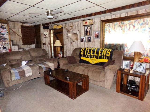 carpeted living room with wood walls