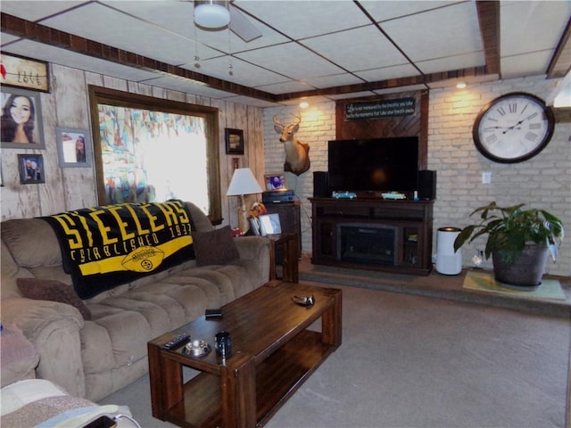 carpeted living area with a drop ceiling and a fireplace