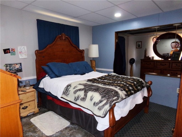 bedroom with a drop ceiling and baseboards