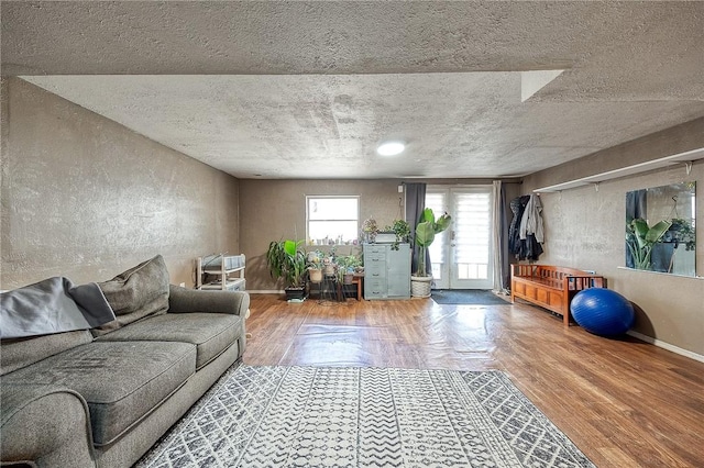 living area featuring baseboards, a textured ceiling, and wood finished floors