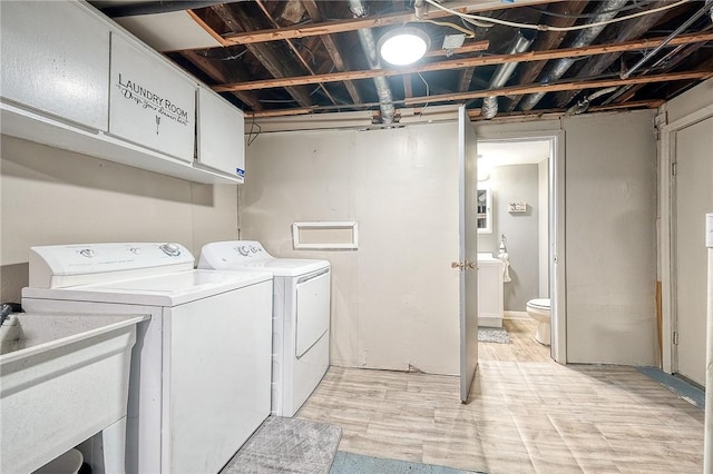 clothes washing area featuring washer and dryer, laundry area, and a sink