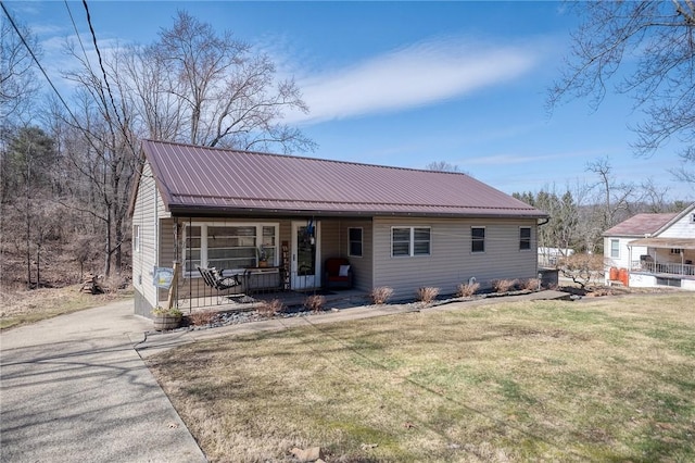 view of front facade with metal roof, a porch, and a front lawn