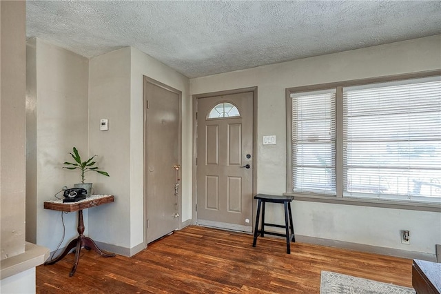 entryway featuring a wealth of natural light, a textured ceiling, baseboards, and wood finished floors