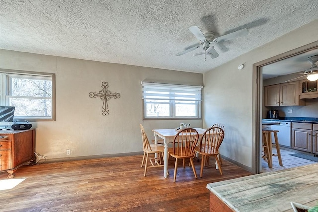 dining room with a textured ceiling, a ceiling fan, baseboards, and wood finished floors