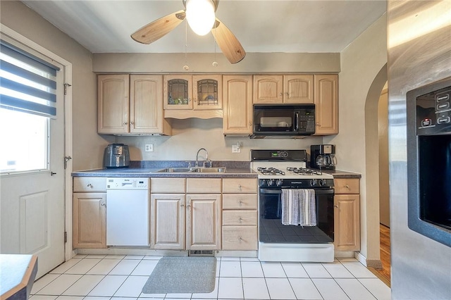 kitchen featuring black microwave, dishwasher, range with gas stovetop, stainless steel refrigerator with ice dispenser, and a sink