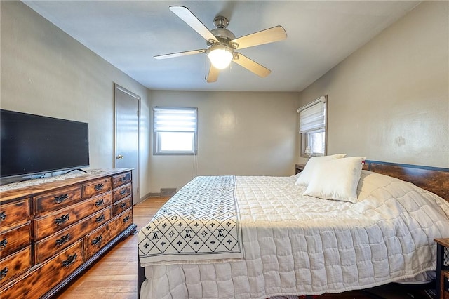 bedroom with baseboards, a ceiling fan, and wood finished floors