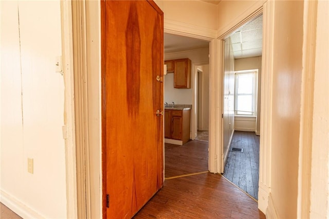 hall featuring visible vents and wood finished floors