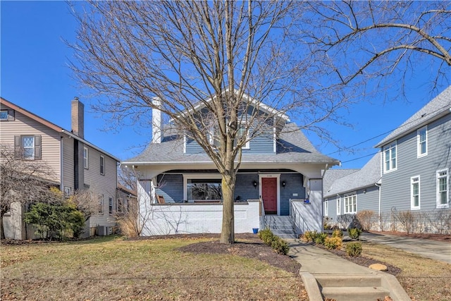 view of front of home featuring a front lawn, central AC unit, and a chimney