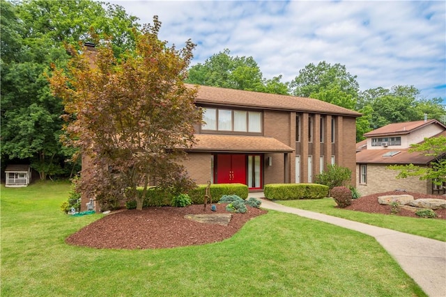 tudor house with brick siding and a front lawn