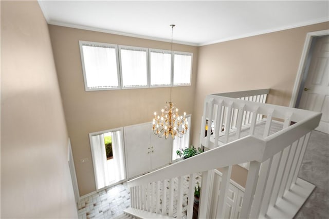 interior space featuring a wealth of natural light, a notable chandelier, a high ceiling, and crown molding