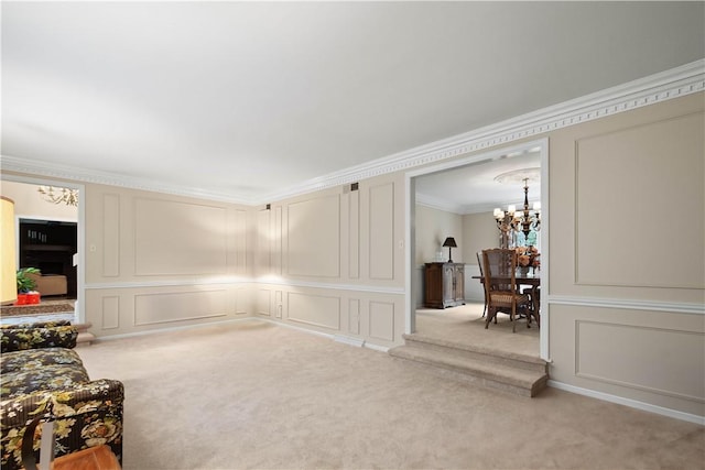 sitting room with a decorative wall, carpet flooring, an inviting chandelier, and ornamental molding