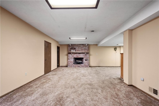 unfurnished living room featuring visible vents, carpet flooring, a fireplace, and baseboards