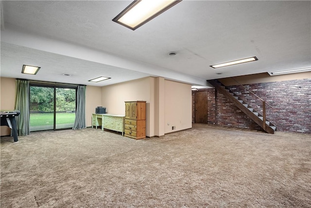 interior space with stairway, carpet, and brick wall