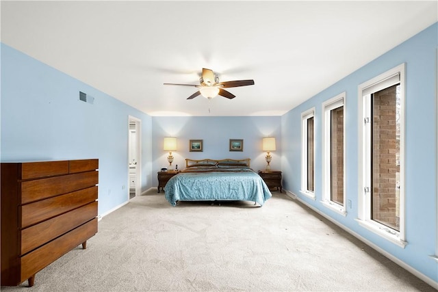 carpeted bedroom with visible vents, a ceiling fan, and baseboards