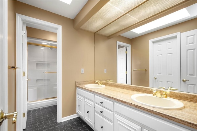 full bathroom with a sink, baseboards, double vanity, and a shower stall