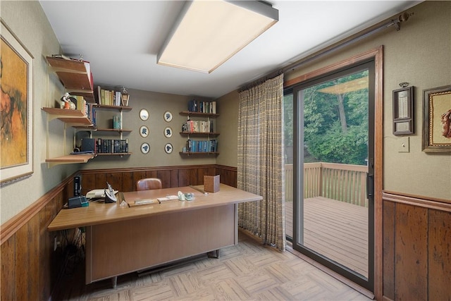 office area featuring wooden walls and a wainscoted wall