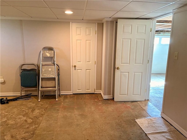 basement featuring a drop ceiling and baseboards