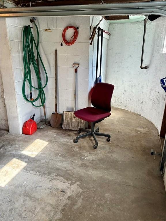 unfinished basement featuring concrete block wall