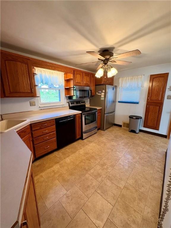 kitchen featuring a sink, light countertops, brown cabinets, stainless steel appliances, and open shelves