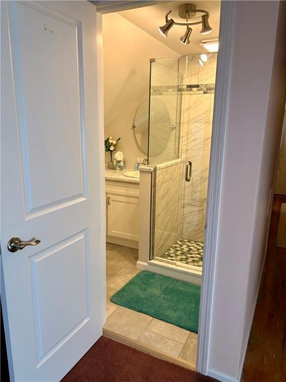 bathroom featuring tile patterned flooring, a shower stall, and vanity