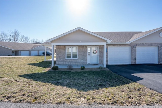 view of front facade featuring a front yard, driveway, roof with shingles, an attached garage, and brick siding