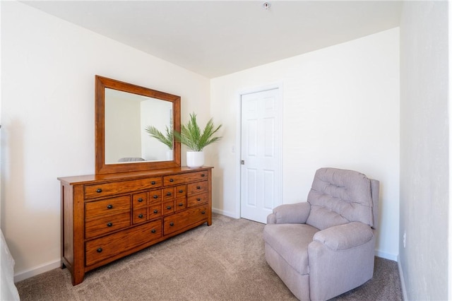 living area featuring light colored carpet and baseboards