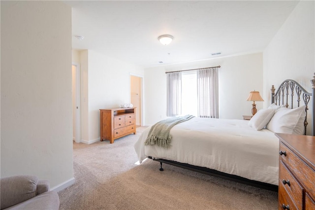 bedroom featuring visible vents, baseboards, and light carpet