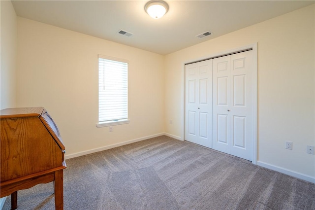 unfurnished bedroom featuring visible vents, baseboards, and carpet