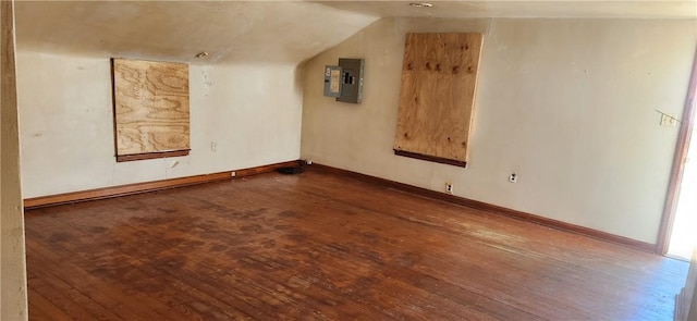 additional living space featuring electric panel, baseboards, vaulted ceiling, and hardwood / wood-style flooring