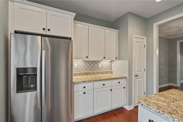 kitchen with light stone counters, dark wood-style flooring, decorative backsplash, stainless steel refrigerator with ice dispenser, and white cabinetry