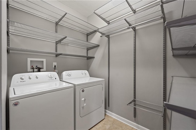 clothes washing area featuring laundry area, washing machine and dryer, and baseboards