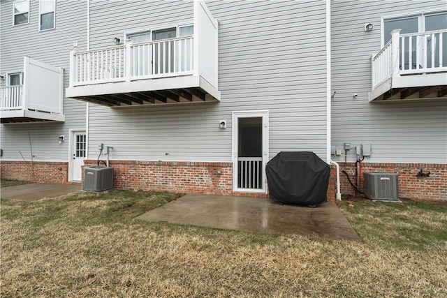 rear view of house featuring a patio area, central air condition unit, and a lawn