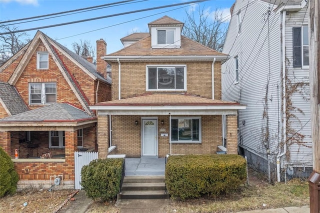 view of front facade with brick siding and a porch