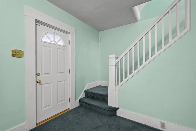 carpeted foyer entrance featuring stairway and baseboards