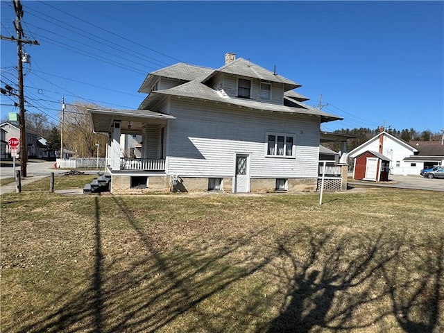 view of property exterior with a porch, a lawn, and a chimney