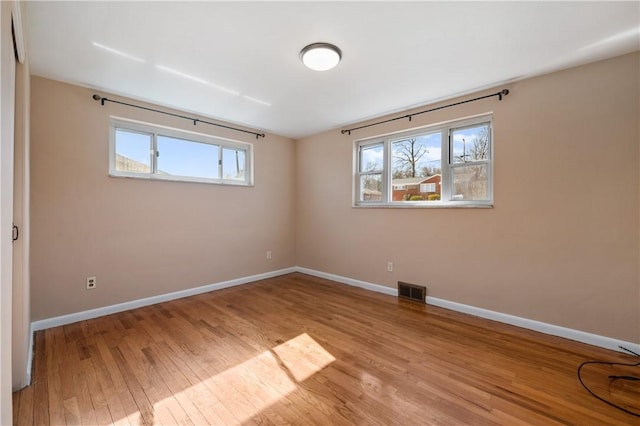 unfurnished bedroom featuring visible vents, baseboards, and wood finished floors