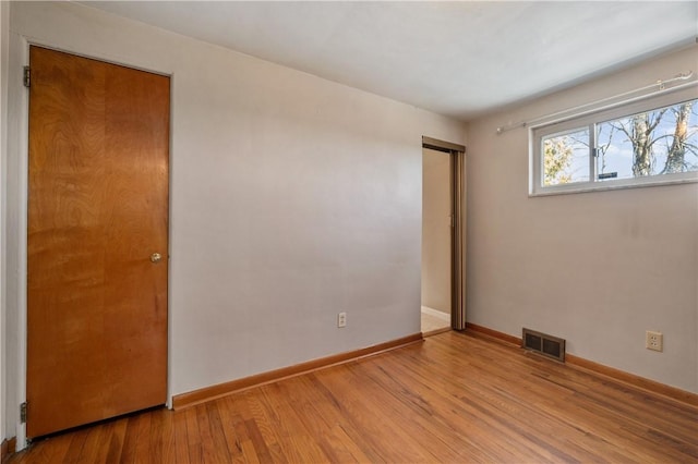 spare room with baseboards, visible vents, and light wood-type flooring