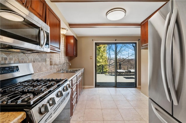 kitchen featuring decorative backsplash, light countertops, appliances with stainless steel finishes, and a sink