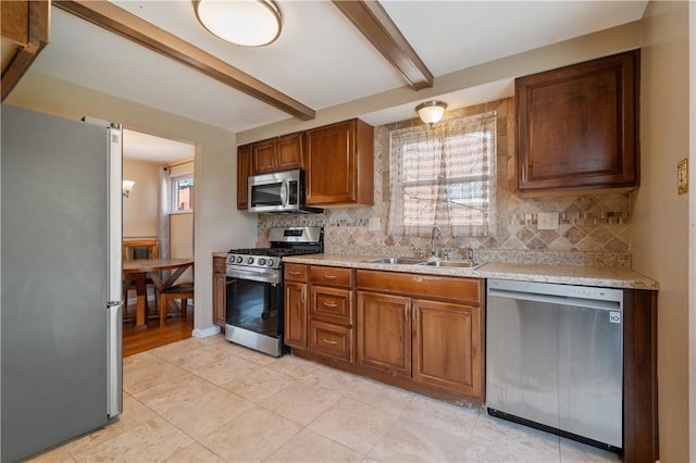 kitchen with tasteful backsplash, beamed ceiling, light countertops, appliances with stainless steel finishes, and a sink