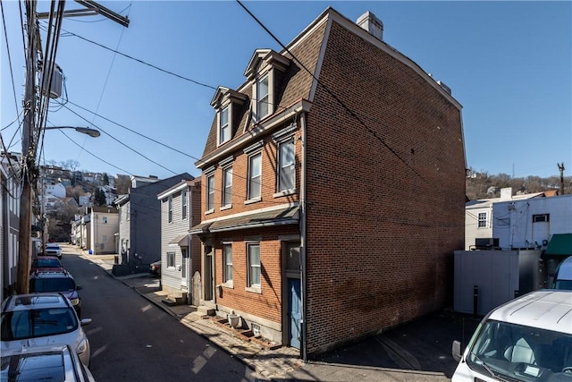 view of home's exterior featuring entry steps, brick siding, and a residential view