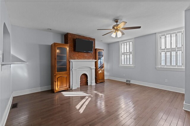 unfurnished living room with visible vents, a ceiling fan, baseboards, and hardwood / wood-style flooring