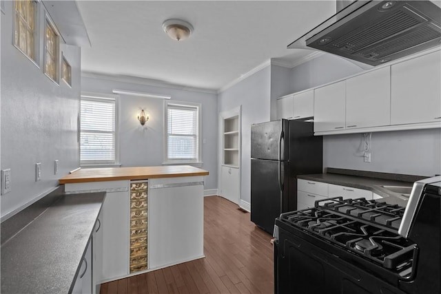 kitchen with freestanding refrigerator, ornamental molding, extractor fan, white cabinets, and range with gas cooktop